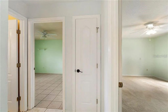 hall featuring light tile patterned floors and a textured ceiling