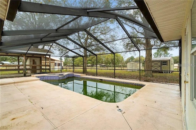 view of swimming pool with a lanai, a patio, and a shed