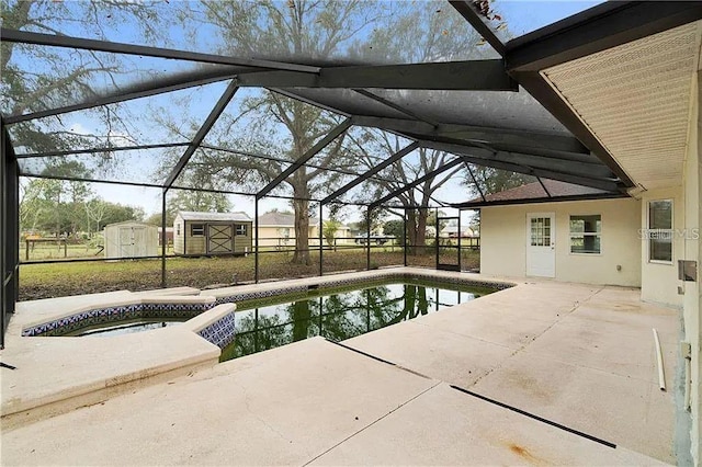 view of swimming pool with glass enclosure, an in ground hot tub, a patio, and a shed