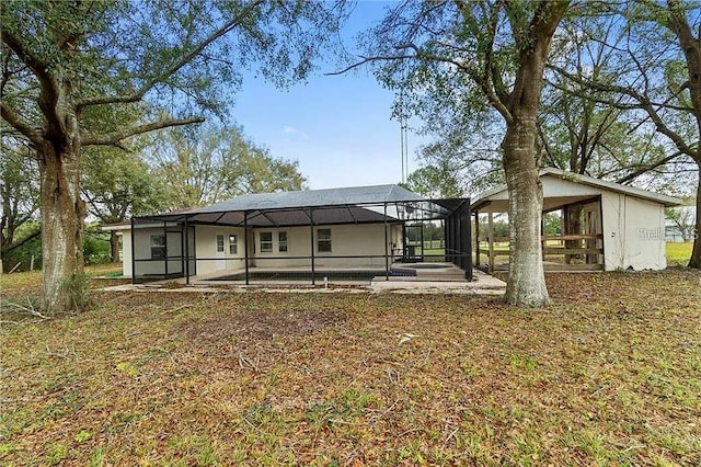 back of house featuring glass enclosure, a patio area, and a pool