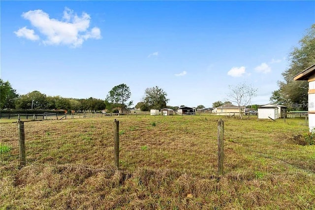 view of yard with a rural view and a shed