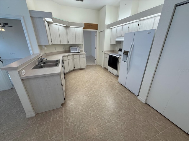 kitchen with ceiling fan, sink, white appliances, and kitchen peninsula