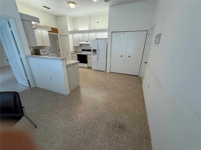 kitchen with electric stove, white cabinetry, and white fridge with ice dispenser