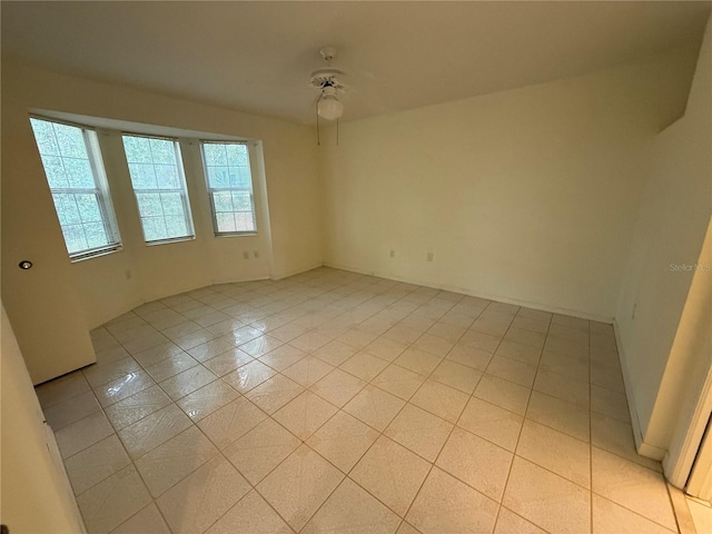 spare room featuring ceiling fan and light tile patterned flooring