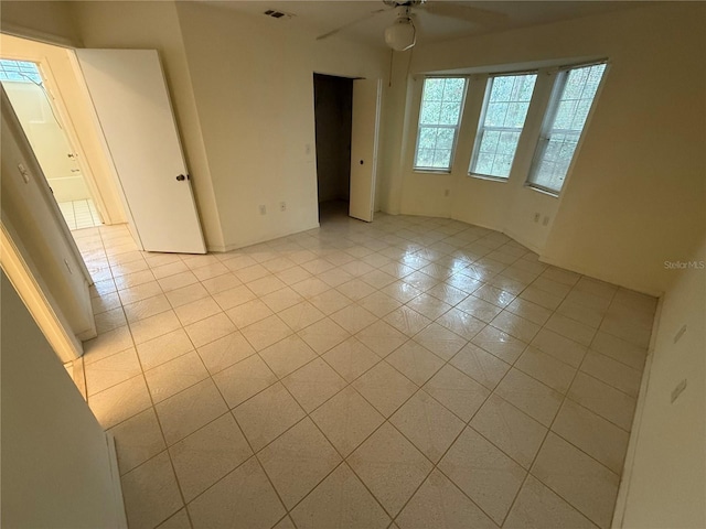 unfurnished room with ceiling fan and light tile patterned flooring