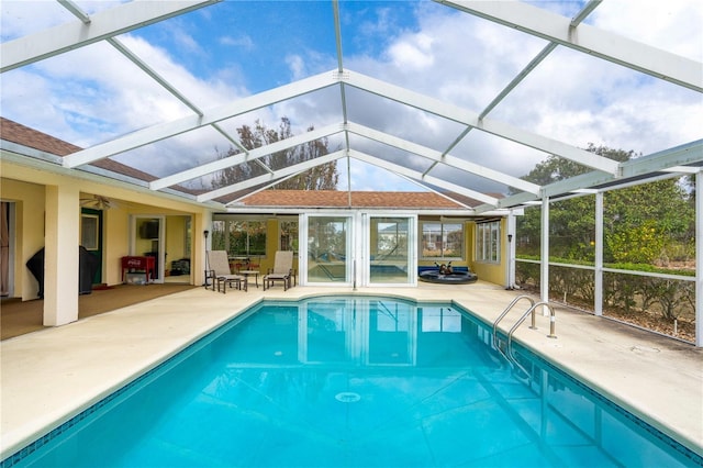 view of swimming pool with a patio area, ceiling fan, and a lanai