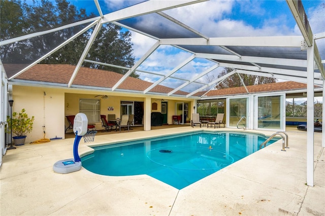 view of swimming pool with a lanai, ceiling fan, and a patio