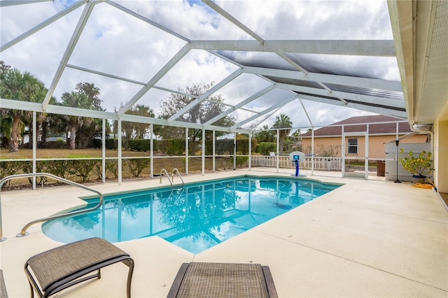 view of pool with a patio and glass enclosure