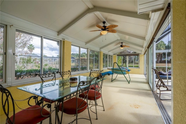 sunroom / solarium with lofted ceiling with beams, ceiling fan, and a healthy amount of sunlight