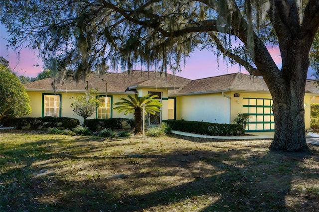 view of front facade with a yard and a garage