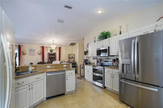 kitchen featuring an inviting chandelier, stainless steel appliances, and white cabinetry