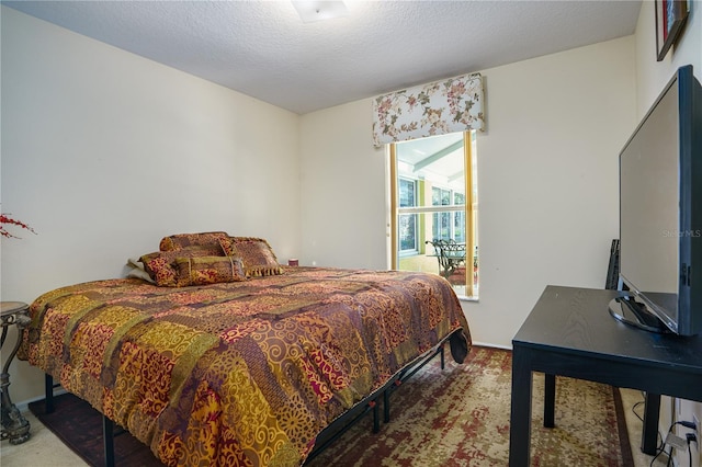 bedroom featuring carpet flooring and a textured ceiling