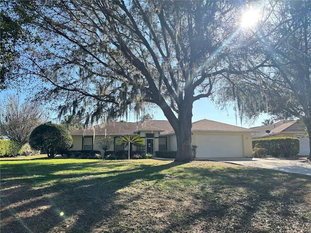 ranch-style home featuring a garage, driveway, a front lawn, and stucco siding