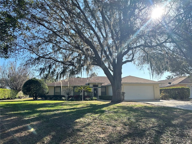 ranch-style home featuring a garage, a front yard, concrete driveway, and stucco siding