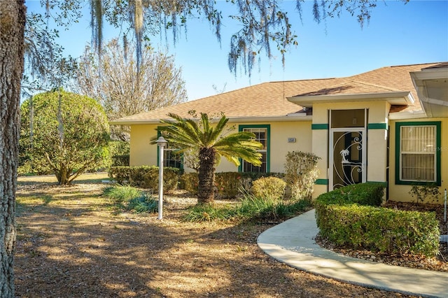 view of front of house featuring a shingled roof and stucco siding