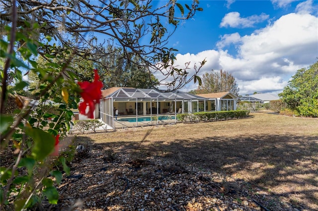 rear view of property with glass enclosure and an outdoor pool