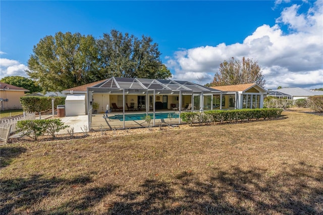 rear view of property featuring a lanai, fence, a yard, an outdoor pool, and a patio area