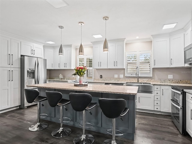 kitchen featuring pendant lighting, a kitchen island, sink, and stainless steel appliances