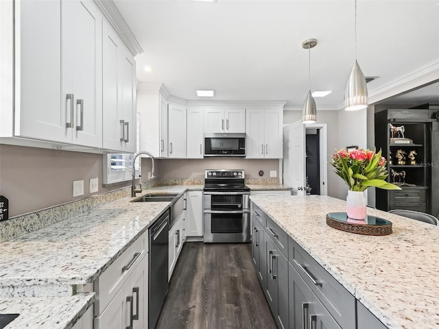 kitchen featuring sink, dark wood-type flooring, stainless steel appliances, pendant lighting, and white cabinets