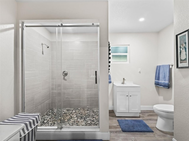 bathroom featuring hardwood / wood-style floors, vanity, toilet, and walk in shower