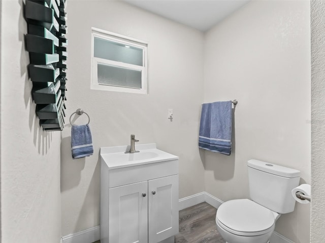 bathroom featuring hardwood / wood-style floors, vanity, and toilet