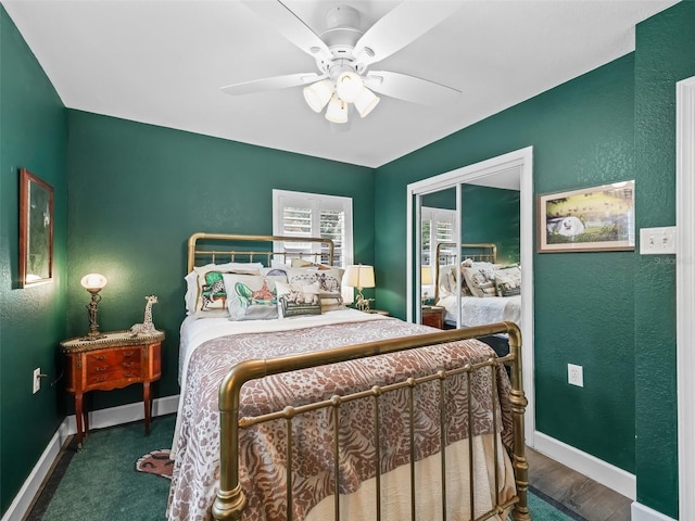 bedroom with ceiling fan, dark wood-type flooring, and a closet