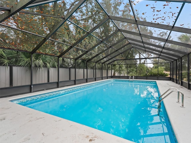 view of pool with glass enclosure and a patio area