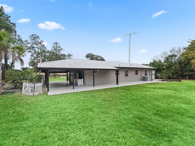 rear view of property featuring a lawn, a patio area, and cooling unit