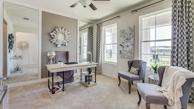 carpeted office space featuring a ceiling fan, visible vents, and baseboards