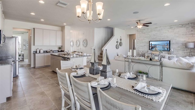 dining area with ceiling fan with notable chandelier, stairway, visible vents, and recessed lighting