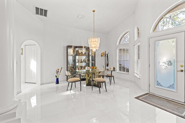 dining area with high vaulted ceiling and a notable chandelier