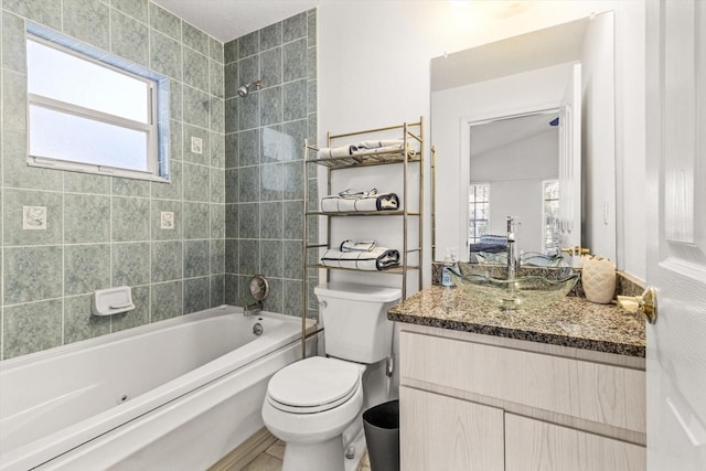 full bathroom featuring vaulted ceiling, vanity, tiled shower / bath combo, and toilet