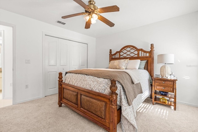 bedroom with ceiling fan, a closet, and light carpet