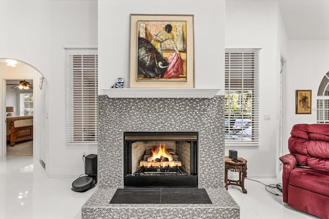 living room featuring a fireplace and ceiling fan