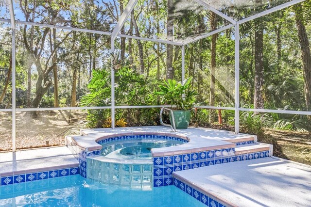 view of pool featuring a lanai and an in ground hot tub