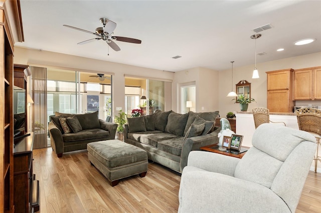 living room featuring light wood-type flooring and ceiling fan