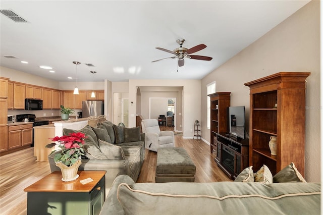 living room with ceiling fan and light hardwood / wood-style flooring