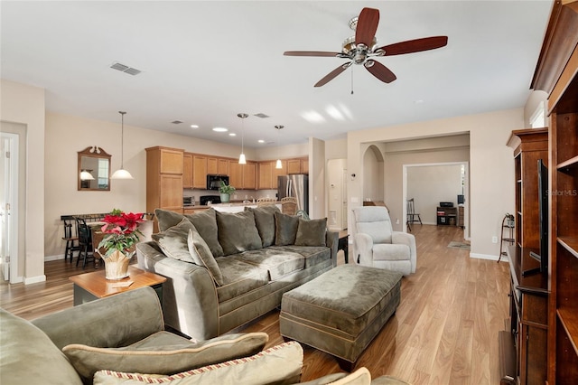 living room featuring ceiling fan and light hardwood / wood-style floors