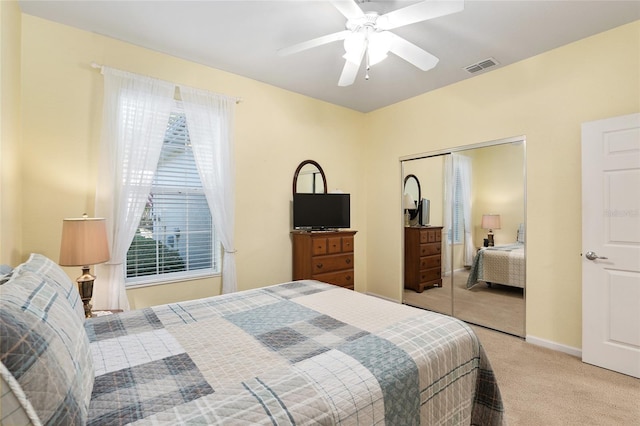 carpeted bedroom with ceiling fan and a closet