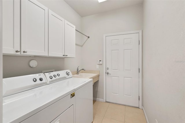 laundry room with cabinets, light tile patterned flooring, washer and clothes dryer, and sink