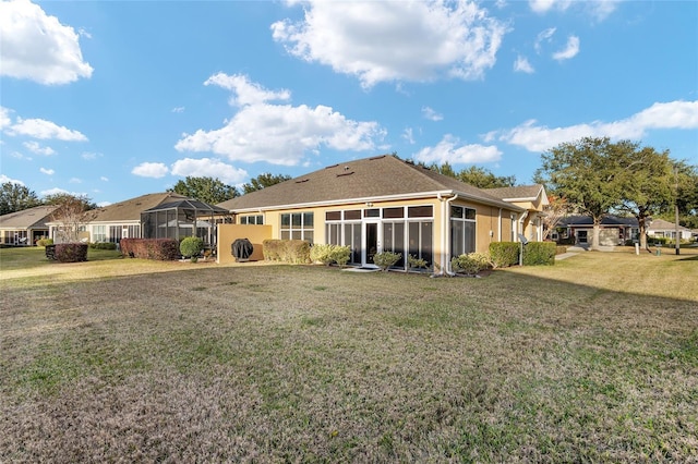 back of house featuring a yard and a sunroom