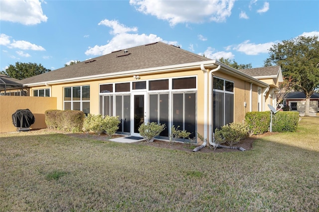 rear view of property featuring a lawn