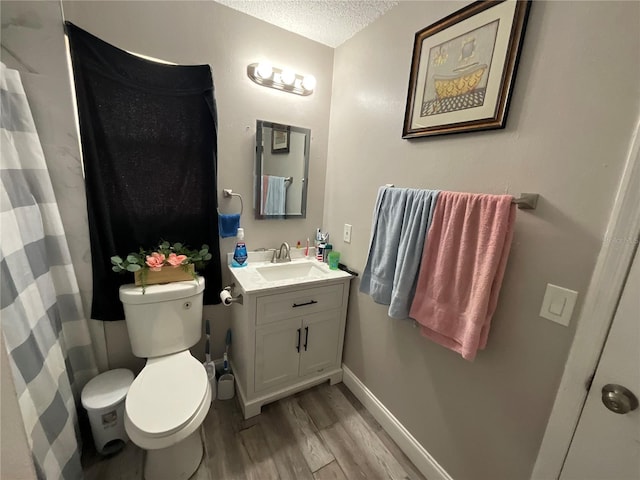 bathroom featuring toilet, vanity, a textured ceiling, and hardwood / wood-style flooring