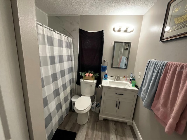 bathroom featuring vanity, toilet, a textured ceiling, curtained shower, and wood-type flooring