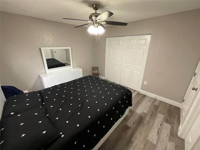 unfurnished bedroom featuring ceiling fan, a closet, wood-type flooring, and a textured ceiling