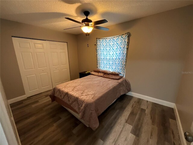 bedroom with ceiling fan, dark hardwood / wood-style floors, a textured ceiling, pool table, and a closet