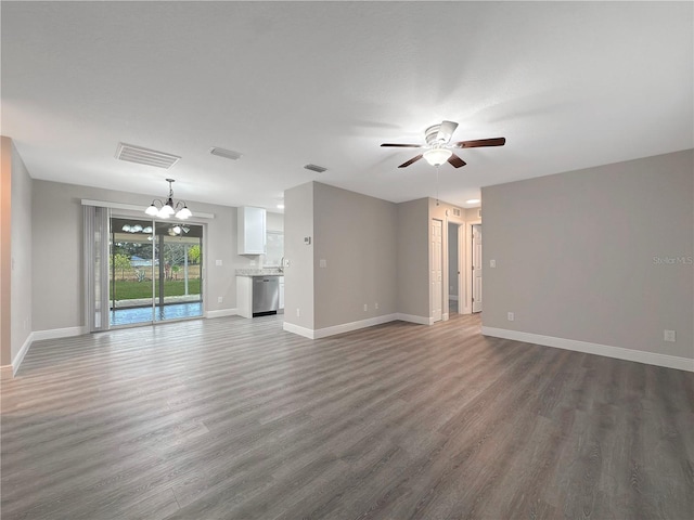 unfurnished living room featuring ceiling fan with notable chandelier and dark wood-type flooring