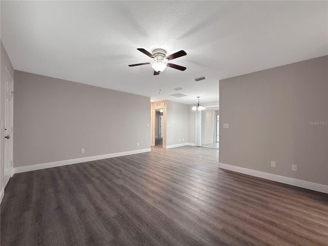 spare room with ceiling fan with notable chandelier, dark hardwood / wood-style flooring, and a textured ceiling