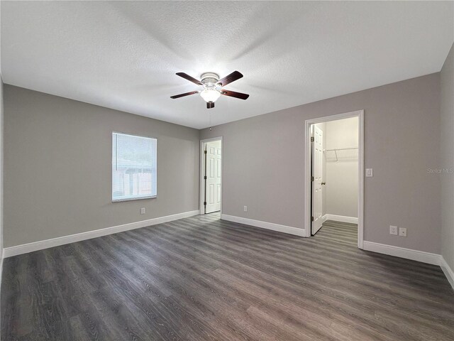 unfurnished room with dark hardwood / wood-style floors, ceiling fan, and a textured ceiling