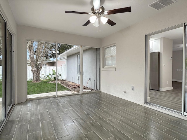 unfurnished sunroom featuring ceiling fan